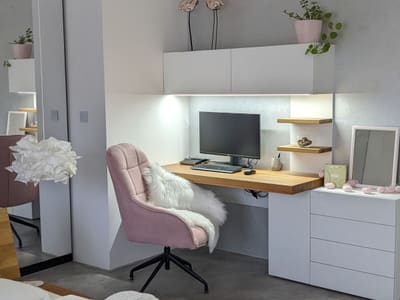 A work corner in a bedroom of the Selfiehome house, with a pink chair and an oak desk